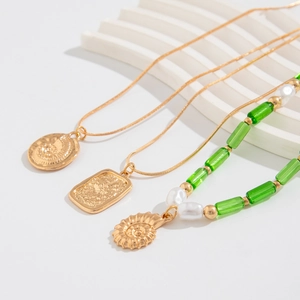 Détail du collier à pendentif coquillage doré avec perles vertes et perles blanches