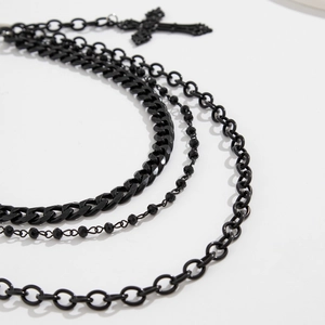 Détail d'une chaîne hip-hop noire multicouche avec pendentif croix de style punk gothique