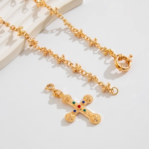 Close-up of gold hip-hop cross necklace with colorful gems and Baroque floral chain