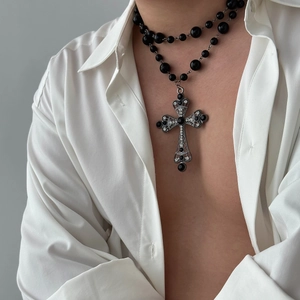 Close-up of gothic layered necklace with black beads and rhinestone cross pendant