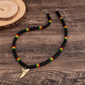 Detail of wooden beads necklace featuring a shark tooth pendant and silver lobster clasp