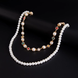 Detail of double-layer vintage pearl necklace with colorful gemstone floral motifs