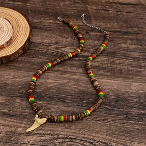 Men's surf necklace with coconut wood beads and white shark tooth pendant on wood background