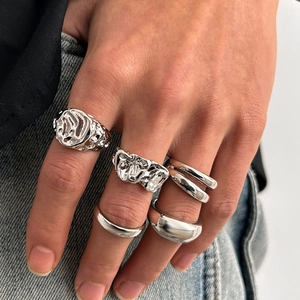 Macro detail of men's punk liquid metal rings with lava texture on hand
