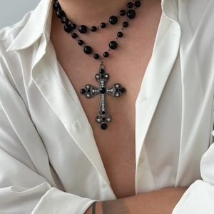 Gothic double-layered black pearl cross necklace for men on a white shirt background