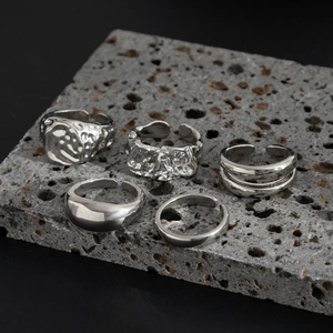 Five-piece set of silver liquid metal rings with lava texture on volcanic stone