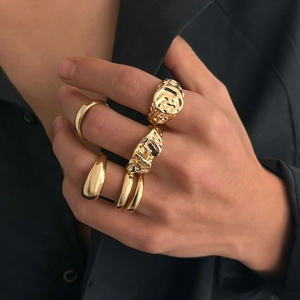 Detail of high-polished gold lava texture and liquid metal rings worn on hand