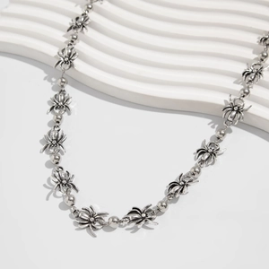 Macro detail of gothic spider pendants and round beads on a punk style silver metal chain