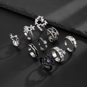 Makroaufnahme von 9er-Set Punk-Ringen mit Dornenmuster und violettem Herz-Edelstein