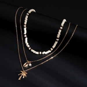 Detail van gelaagde zomerketting met kokosnootboom hanger en schelpvormige bedeltjes