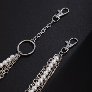 Macro detail of high-quality pearl and silver metal chain layers for trousers