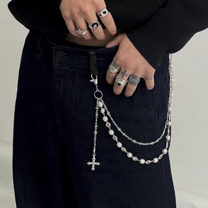 Detail of multi-layer hip hop waist chain with silver crosses, pearls and colored gems