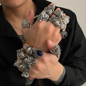 Détail de bagues punk gothiques avec crâne, tête de lion et pierre précieuse bleue