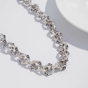 Close-up of punk style trousers chain with vintage silver skull engraved metal rings
