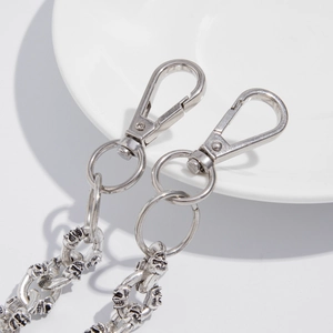 Macro detail of silver metal skull links and lobster clasp on punk hip-hop pants chain