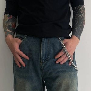 Detail view of hip-hop silver ball and link metal pants chain on denim jeans