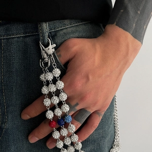 Détail d'une chaîne de taille hip hop avec maillons argentés et boules de strass colorées