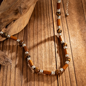 Detail of beaded necklace with tiger eye stones, wooden beads and silver metal spacers