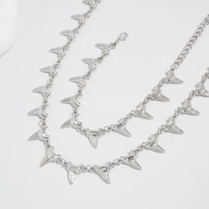 Detailed view of silver shark tooth pendant necklace with polished finish and lobster clasp