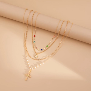 Détail d'un collier doré à 5 couches avec pendentif soleil, perles et cristaux