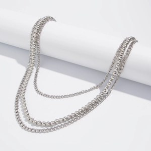 Detail of triple-layer silver hip-hop chain featuring ball, cross, and curb links