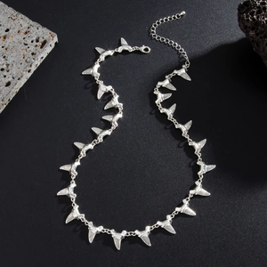 Detail of silver shark tooth chain necklace with textured alloy pendants and lobster clasp
