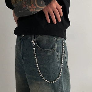 Silver metal pants chain with rivets and spikes on dark denim jeans for punk hip-hop style