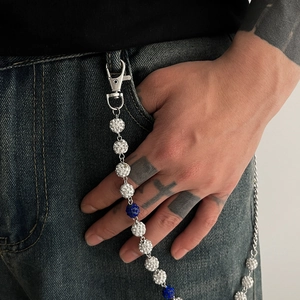 Détail de la chaîne de pantalon hip hop avec fermoirs argentés et perles bleues brillantes