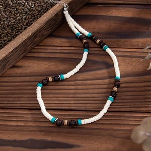 Dettagli di perle in conchiglia e legno su una collana surfer boho con chiusura a moschettone