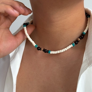 Dettaglio della collana bohémien fatta a mano con perline di cocco su camicia