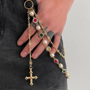 Detail of multi-layer gold hip hop pants chain with pearls, colorful gems and cross