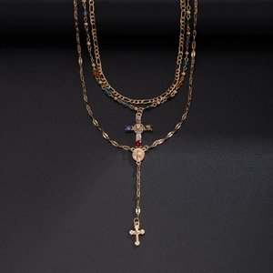 Dettaglio della collana a strati dorata con ciondoli a croce e perline colorate da uomo