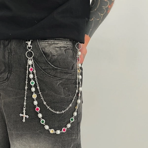 Detail of multi-layer punk pants chain with rhinestones, faux pearls and cross charm