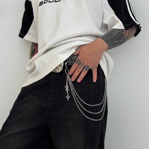Close-up of triple-layered silver trouser chain with star pendants on jeans