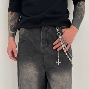 Close-up of triple-layered metal hip-hop pants chain with colorful gems and a cross pendant