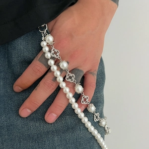 Macro detail of double-layer pearl and diamond flower pendant on hip-hop pants chain
