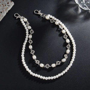 Detail of double-layer faux pearl trousers chain with silver clover pendants and lobster clasps