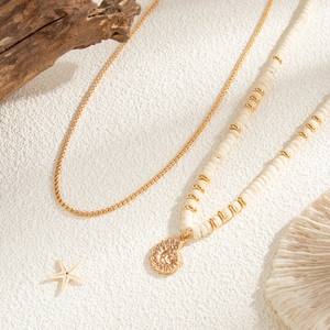 Detail of double-layer coconut shell bead necklace with golden conch shell pendant