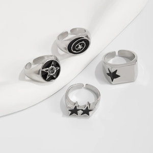 Dettaglio di set anelli punk in argento con stella in smalto nero e fasce regolabili