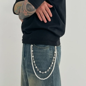 Detail of hip hop double-layer pearl pants chain with cross charms on denim jeans