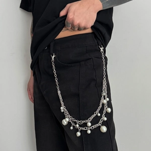 Close-up of double-layer silver trouser chain with pearls on black denim jeans