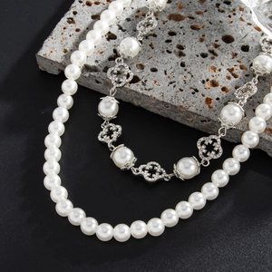Detailed shot of hip-hop faux pearl chain with diamond-encrusted flower charms on stone