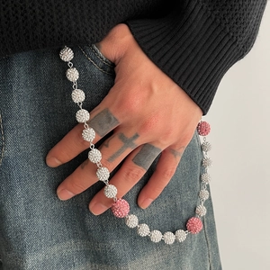 Détail de la chaîne de pantalon hip-hop avec des sphères en strass pavées roses et argentées