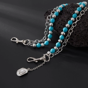 Detail of turquoise beaded waist chain featuring a silver cowboy hat pendant and lobster clasp