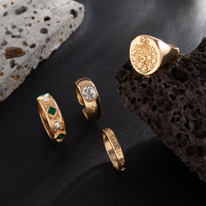 Vierteiliges vergoldetes Ring-Set mit Löwenwappen, grünem Smaragd und Kreuzrelief-Details