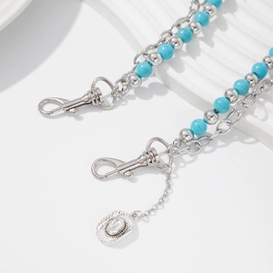 Detail of turquoise beaded waist chain featuring a silver cowboy hat charm and spring hooks