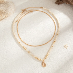 Detail of double-layer coconut shell beaded necklace with golden conch shell pendant and beads
