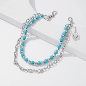 Detail of double-layer chain with turquoise beads and silver cowboy hat pendant charm
