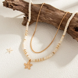 Close-up of double-layered coconut shell bead necklace with a gold starfish pendant