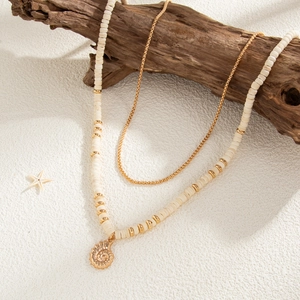 Detail of layered coconut shell bead necklace with a golden nautilus pendant and sea star